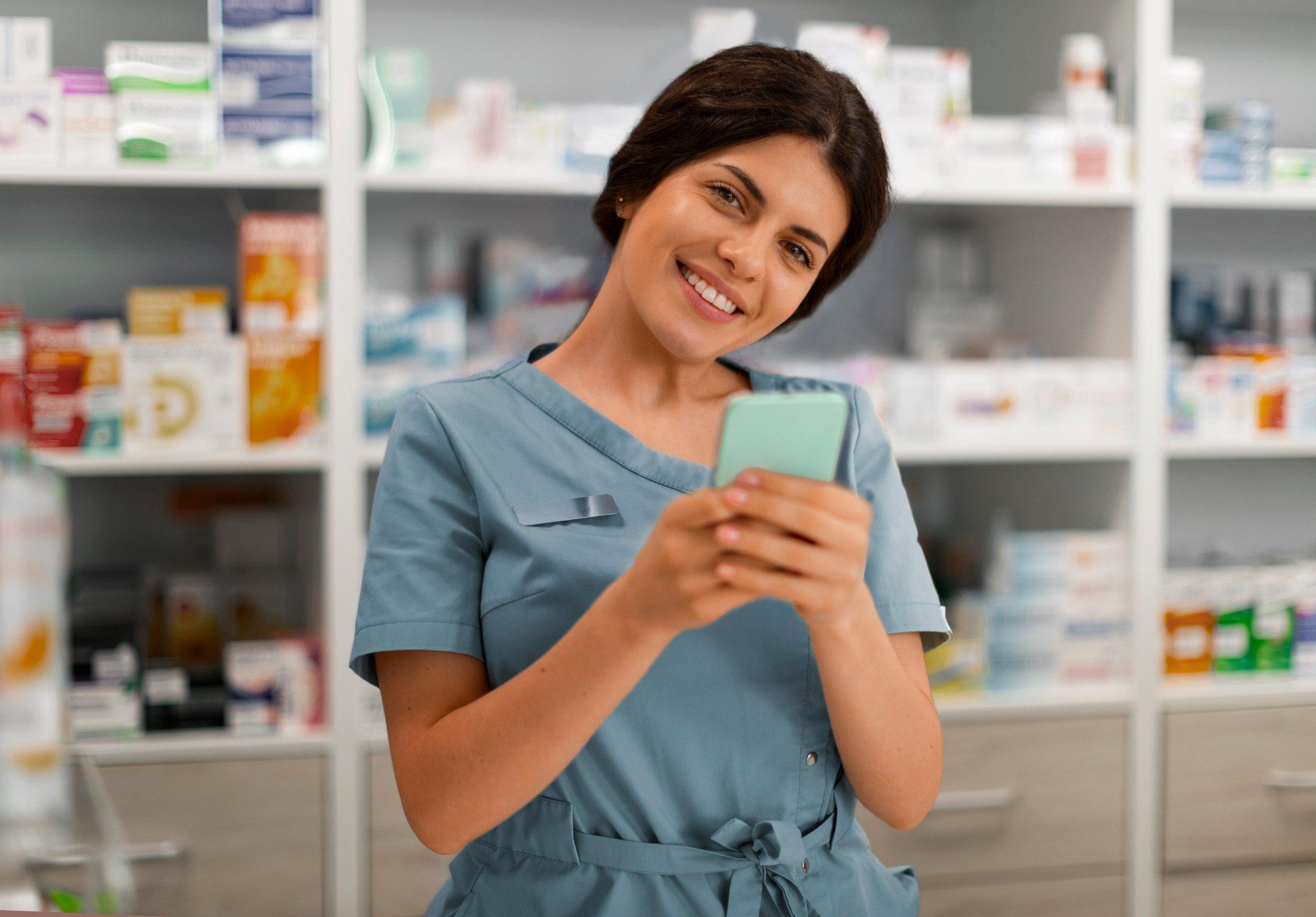 Farmacêutica sorrindo enquanto confere um pagamento no celular