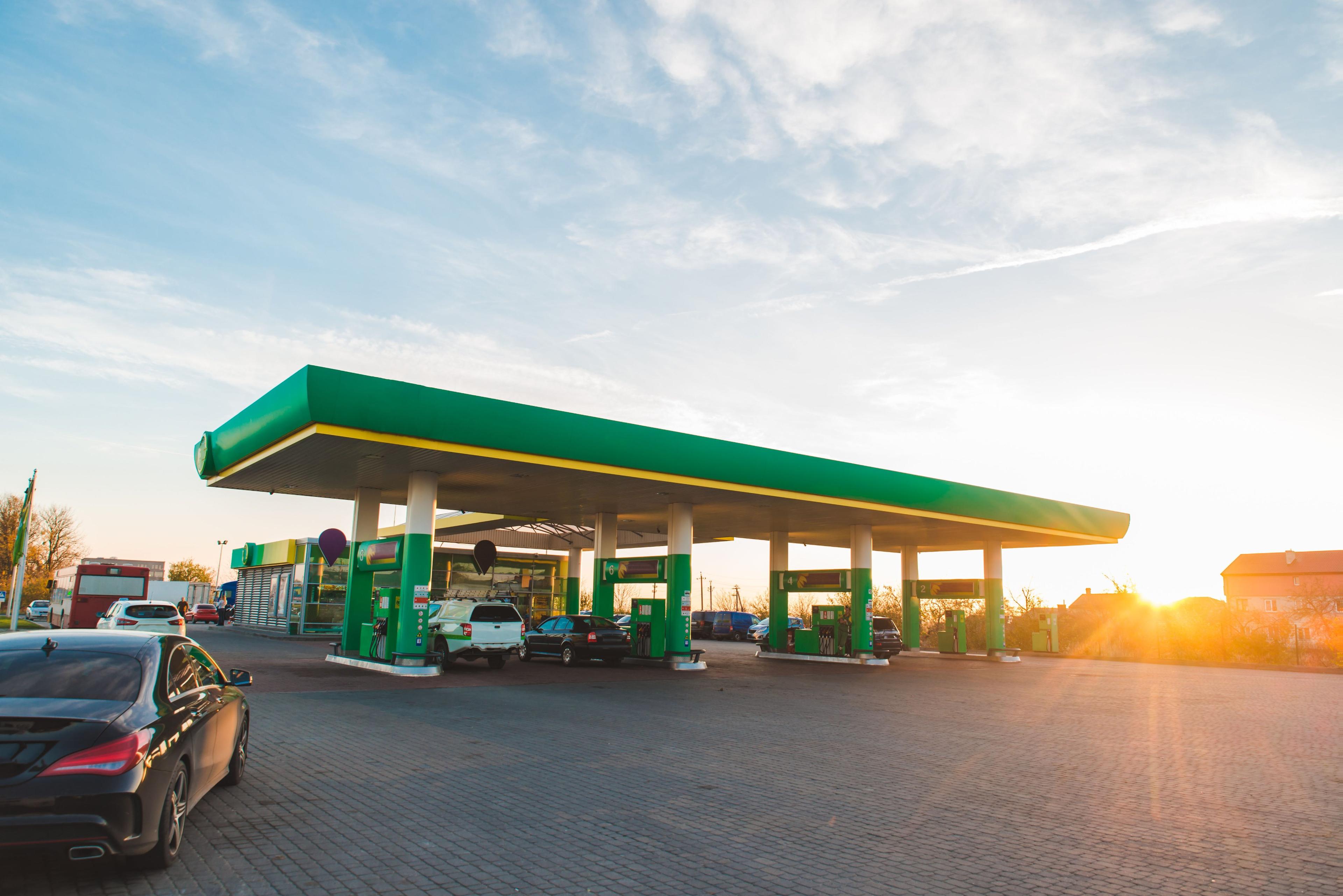 Posto de combustível ao entardecer com veículos abastecendo